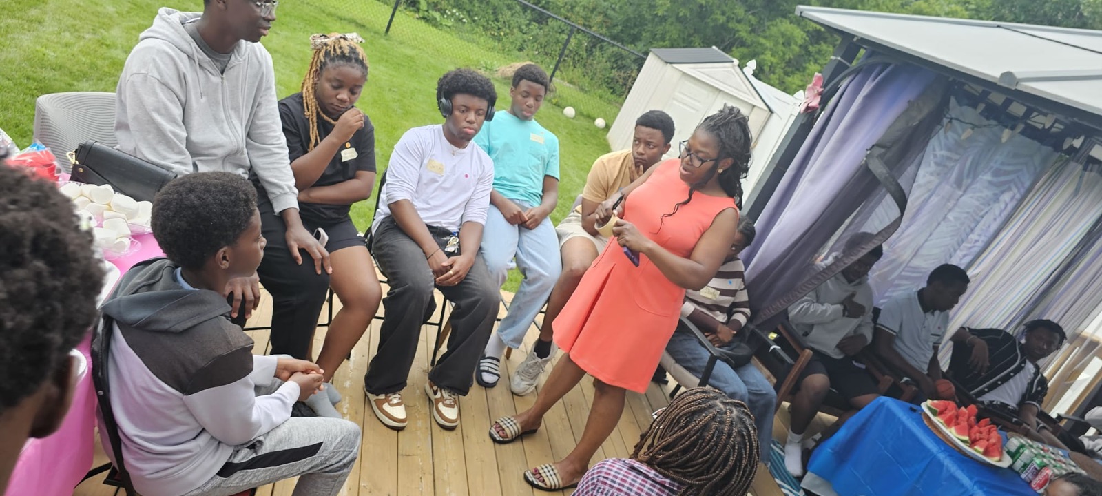 Youth and a mentor in an open peer support circle on the deck, talking through stress and self-image